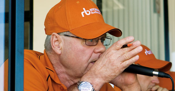 A Ritchie Bros. auctioneer selling heavy equipment and trucks